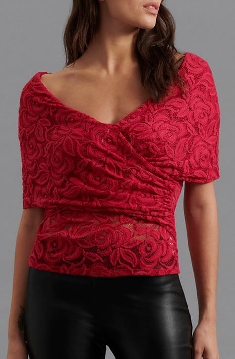 The JINKOA is an faux wrap top in pink lace. The JINKOA is enhanced with a subtle v-neckline and an off the shoulder sleeve.