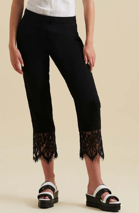 The GABI are ankle length black crepe pants enhanced with a wide delicate eyelash scalloped black lace along the hem of each pant leg. These ankle length pants feature a center-front zipper with a hook and eye for closure and Italian side pockets.